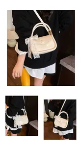 Detail view of cream leather crossbody bag featuring a delicate white lace bow accessory
