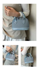 Macro view of light blue shell bag featuring textured fabric and leather trim