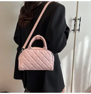 Pink quilted leather Boston bag worn with black suit for a stylish crossbody look