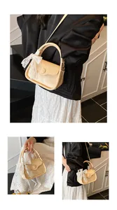 Detail of cream crossbody bag featuring lychee texture and large white lace bow accent