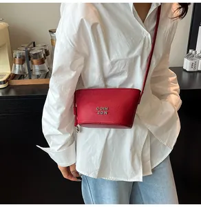 Élégant sac seau rouge en cuir grainé assorti à une tenue avec chemise blanche