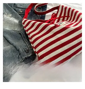 Detailed view of red and white striped canvas tote with a YOU woven fabric label
