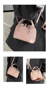 Detailed view of pink shell-shaped crossbody bag with silver zippers and textures