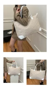 Detail of large houndstooth travel tote with white handles on a female model