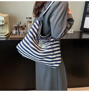 Close-up of blue striped canvas tote with SEEYOU label and ribbon bow detail