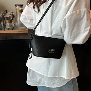 Sac bandoulière minimaliste en cuir noir avec logo argenté pour femme