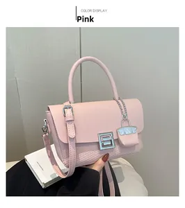 Detail of pink shoulder bag featuring woven texture and silver S-shaped buckle closure
