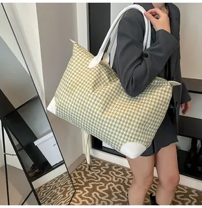 Detailed look at the large houndstooth travel bag styled on a model in a modern room