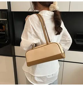 Detail of minimalist beige woven shoulder bag with brown leather trim and slim straps