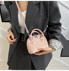Detailed close-up of a pink textured shell bag with woven pattern and metallic zippers