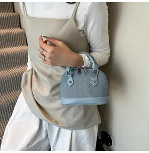 Detail of light blue shell handbag with twill fabric texture and silver hardware accents