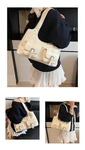 Detail view of large cream PU tote bag showing front pockets and metallic buckle straps