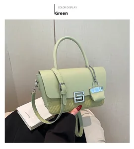Detail of green shoulder bag featuring woven texture and decorative metal G-lock