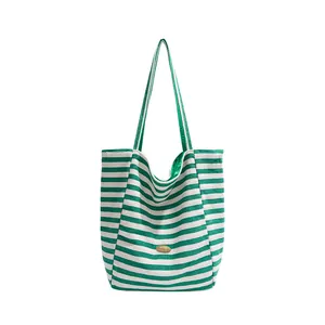 Striped canvas tote bag in green and white with gold handmade metal plaque