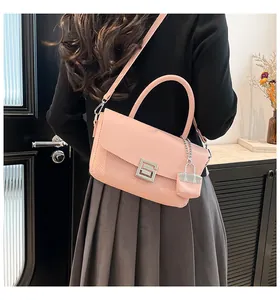 Detail of pink faux leather crossbody bag showing snake texture and silver metal buckle