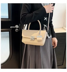 Detail of beige paneled crossbody bag with woven texture and square metal lock
