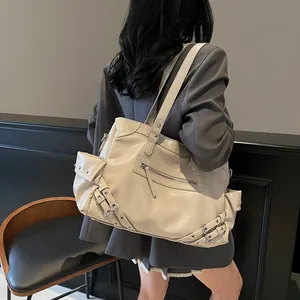 Rock-style cream studded tote bag in high-gloss faux leather shown on a model