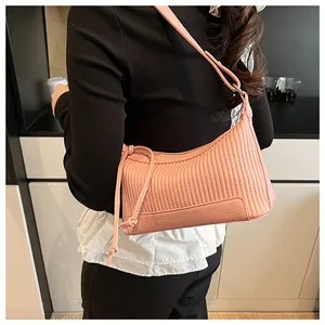 Close-up of pink pleated shoulder bag with vertical texture and drawstring detail