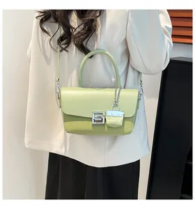 Detail view of light green crossbody bag with silver S-shaped buckle and woven texture