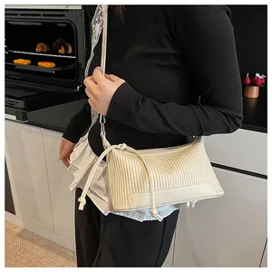 Detail of cream white pleated shoulder bag featuring drawstring knots and lychee texture