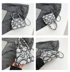 Detailansichten der Schlangenstruktur auf Schalenhandtasche mit verstellbarem Riemen