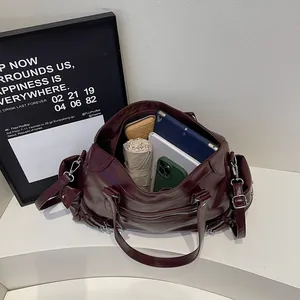 Large burgundy studded tote bag showing spacious interior with tablet and daily essentials