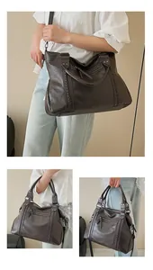 Detail of dark brown tote bag with vintage leather texture and woven stitch accents