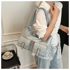 Detail shot of blue PU leather shoulder bag featuring dual buckled flap pockets