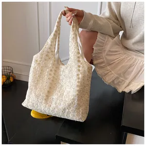 Close-up of ivory lace tote bag showing delicate 3D floral embroidery and mesh texture