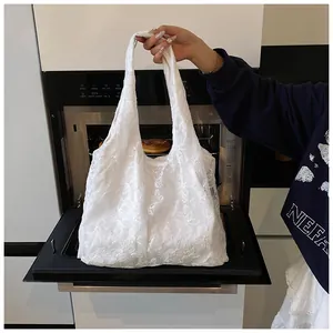 Detailed close-up of white mesh tote bag featuring 3D floral embroidery and textures