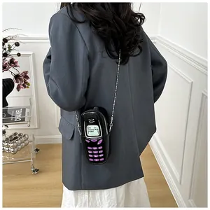 Dettaglio della borsa a telefono creativa con testo Delete My Number e catena in metallo