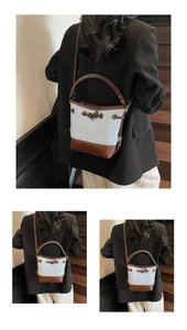 Dettaglio della borsa a secchiello vintage in tessuto azzurro e tracolla in pelle marrone