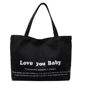 Minimalist black canvas tote bag with white letter print and durable shoulder straps