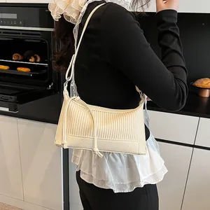 Minimalist beige pleated underarm bag with thin knotted shoulder strap for women