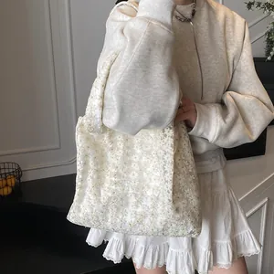 Elegant white lace tote bag featuring 3D floral embroidery for a minimalist summer look