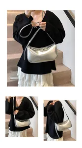 Detailed macro view of stylish silver metallic crescent shoulder bag with smooth texture