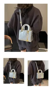 Detail view of silver crossbody bag with embossed cartoon rabbit and bear patterns