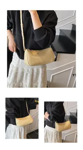 Detail view of cream minimalist baguette bag with polished leather texture and logo