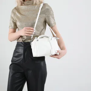 Elegante weiße Handtasche mit Litschi-Textur und Silberbeschlägen am Modell