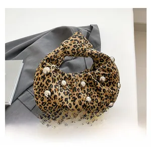 Close-up of leopard print canvas bag with silver studs and knotted handle detail