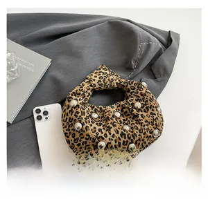 Close-up of leopard print canvas handbag with silver studs and knotted handle detail