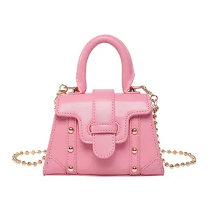 Minimalistische rosa quadratische Handtasche mit goldenen Nieten und rundem Griff