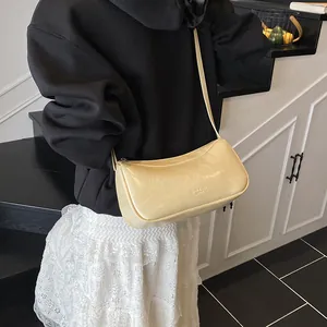 Minimalist beige underarm bag in polished synthetic leather with slim shoulder strap