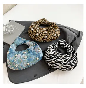 Detailed view of knots and metal ball accents on leopard, floral, and zebra print handbags
