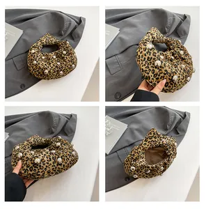 Detailed views of leopard print knot bag with silver studs and smooth interior lining