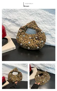 Detail of leopard print tote bag featuring silver metal studs and knotted handle design