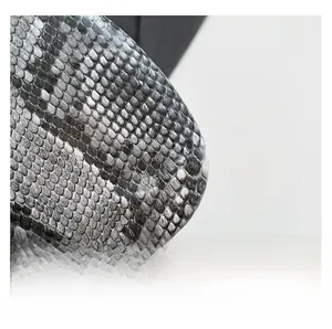Close-up detail of high-quality faux snake skin texture on a stylish fashion handbag