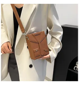 Detailed view of the creative brown suit-style leather crossbody bag on a model