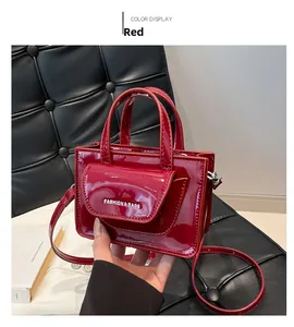 Detailansicht der glänzenden Lackleder Mini-Handtasche in Dunkelrot mit Doppelgriff