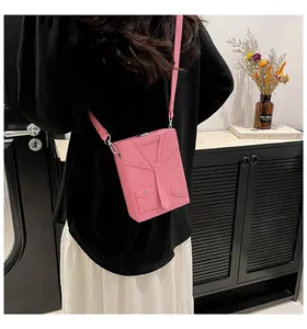 Detail view of pink suit-style crossbody bag with tie design and lychee leather texture